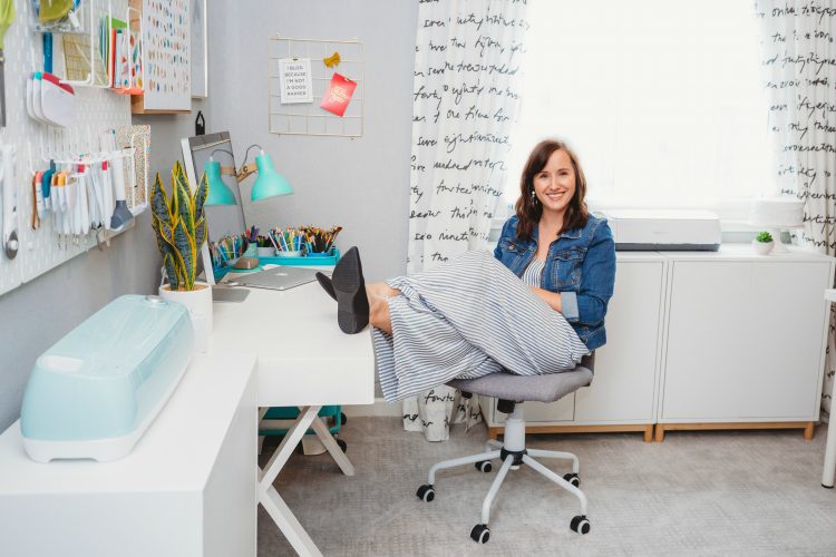 Cori George sitting in her craft room with her feet resting on her desk