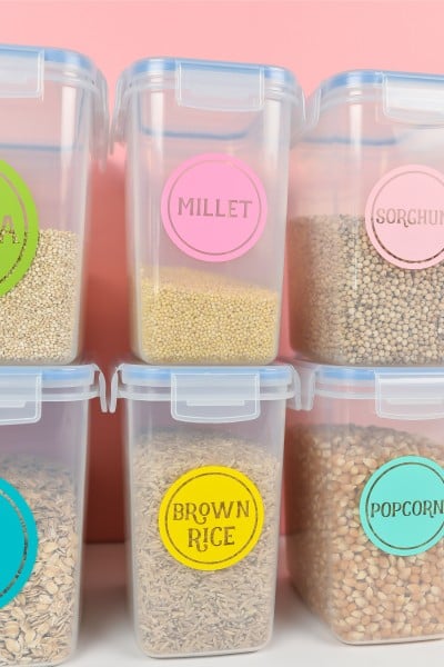 Stacked containers of pantry food staples labeled with colorful labels