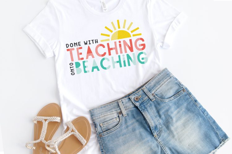 A close up of a pair of white sandals, blue jean shorts and a white t-shirt with the design of a half of a sun and the saying, \"Done with Teaching onto Beaching\"