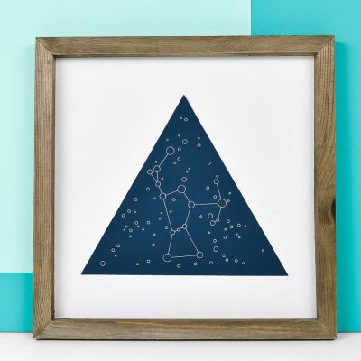 A close up of a wooden framed picture of the Orion constellation
