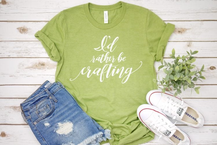 A close up of tennis shoes, blue jean shorts and a lime green shirt with the saying, \"I\'d Rather be Crafting\"