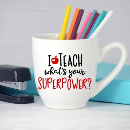 Large white coffee mug with colored pencils in it and the saying I Teach, What’s your Superpower? on it