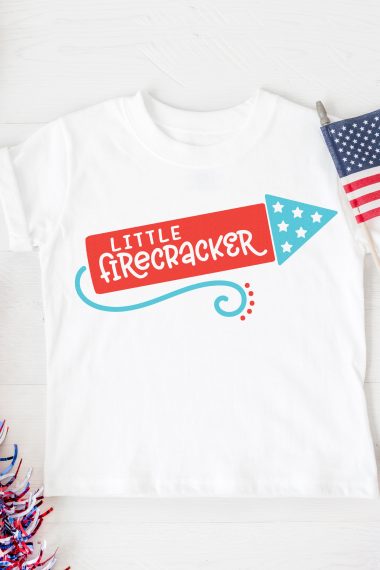 White t-shirt with a firecracker image, that says, "Little Firecracker"