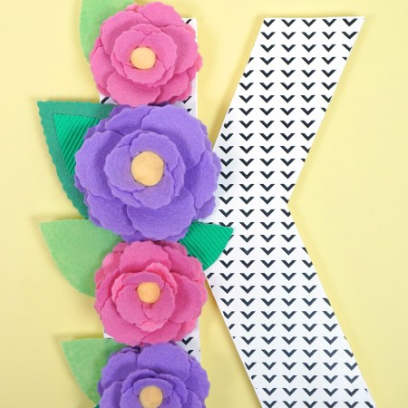 The letter "K" decorated with paper flowers and leaves