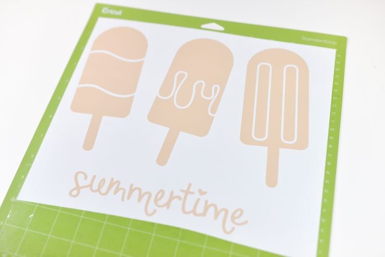 Cut file on a Cricut mat of three popsicle images and the word summertime