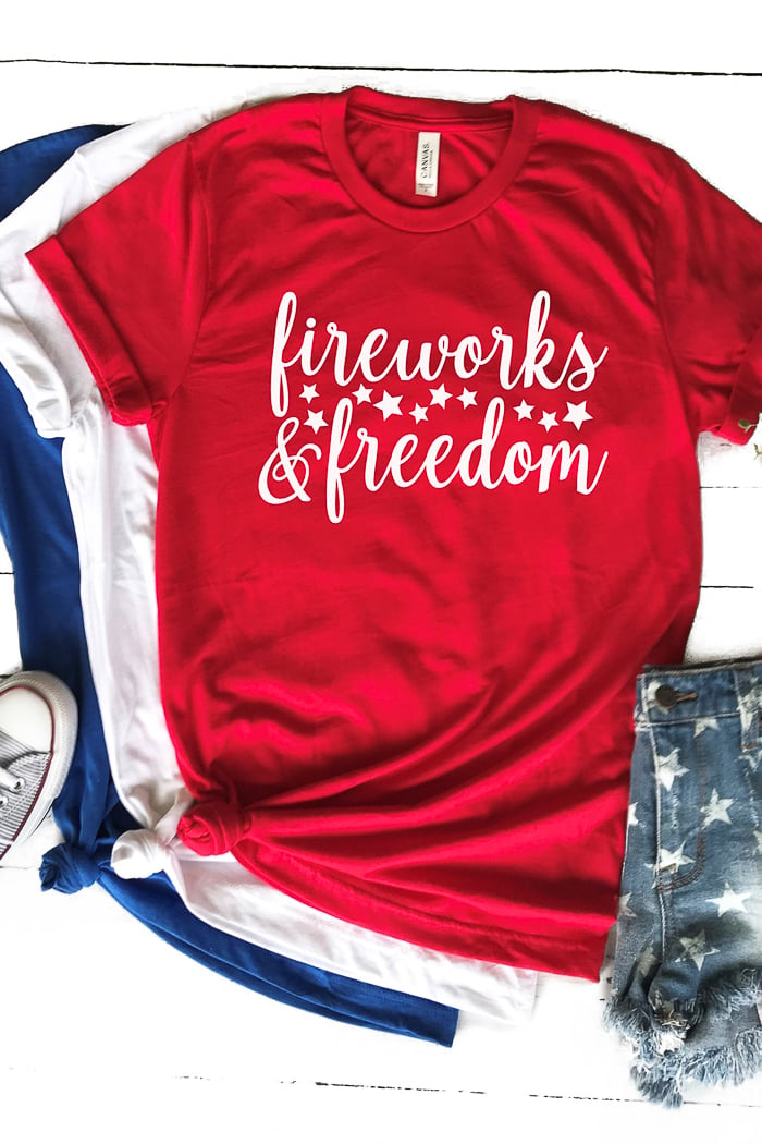 Blue jean shorts, one tennis shoes and a blue t-shirt, a white t-shirt and a red t-shirt that says, "Fireworks and Freedom"