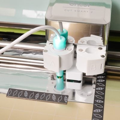Image of a Cricut machine loaded with the foil quill magnetic mat