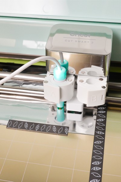 Image of a Cricut machine loaded with the foil quill magnetic mat