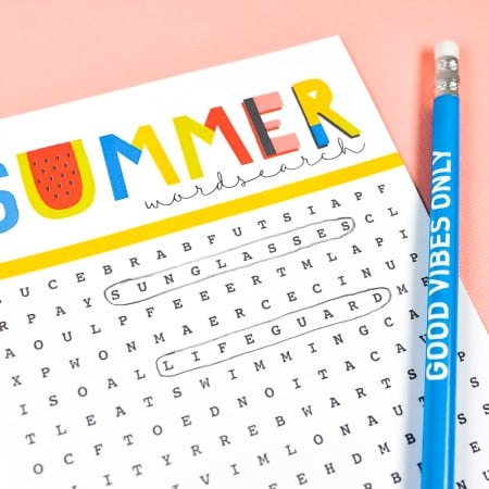 Close-up of a blue pencil lying next to a Summer Word Search puzzle