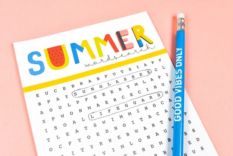 Close-up of a blue pencil lying next to a Summer Word Search puzzle