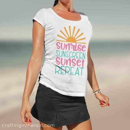 Woman wearing a white t-shirt that says, Sunrise, Sunscreen, Sunset, Repeat