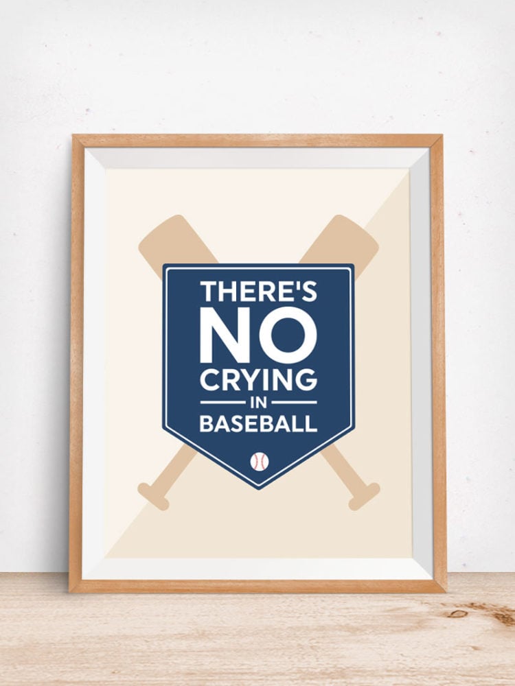 A wooden framed printable of two crossed baseball bats with a banner over top of the saying, \'There\'s No Crying in Baseball\"