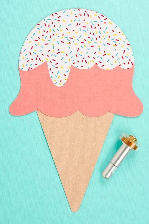 A close up of an image of the Cricut Maker Debossing Tool next to a cutout of an ice cream cone with two scoops of ice cream and sprinkles