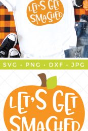 Halloween decor around a pair of blue jeans, a pair of tennis shoes and a white t-shirt that is decorated with an orange pumpkin that says, "Let's Get Smashed" and an advertisement of the cut file "Let's Get Smashed" by HEYLETSMAKESTUFF.COM