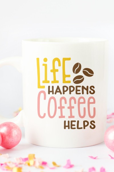 Pink ornaments and confetti surrounding a coffee cup with the saying, "Life Happens Coffee Helps"