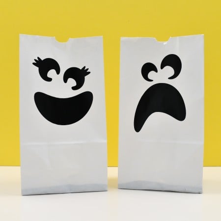 White luminarias / luminaries' bags with design of a ghost on each one