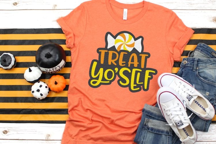 Fall decor surrounding a pair of blue jeans, tennis shoes and an orange t-shirt designed with a piece of Halloween candy and the saying, \"Treat Yo\'Self\"