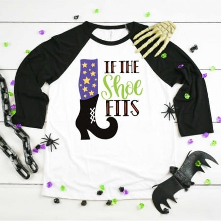 Black and white baseball style shirt with w witches leg and show image and the saying If the Shoe Fits