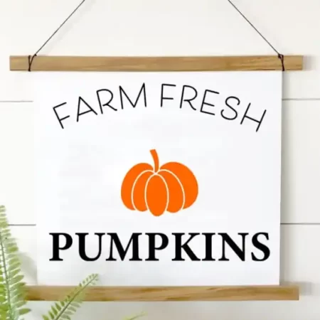 White hanging sign that says Farm Fresh Pumpkins