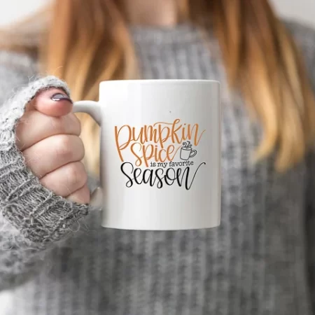 Woman holding a white coffee mug that says Pumpkin Spice is my Favorite Season