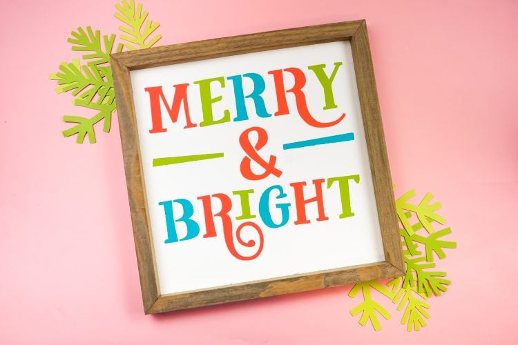 A close up of a wooden framed sign that says \"Merry & Bright\"