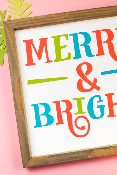 A close up of a wooden framed sign that says "Merry & Bright"