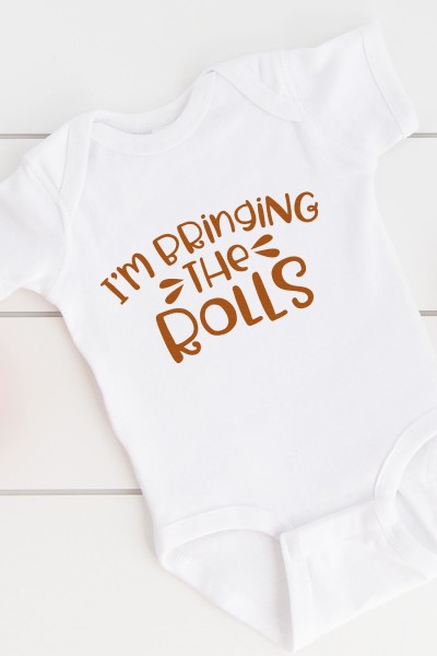 A white onesie with the saying, "I'm Bringing the Rolls"