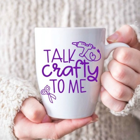 Woman holding a coffee mug that says Talk Crafty to Me