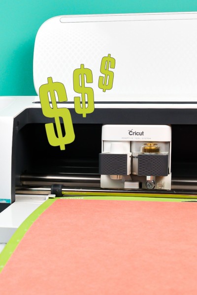 image of a Cricut machine with 3 Dollar Signs floating in the air.