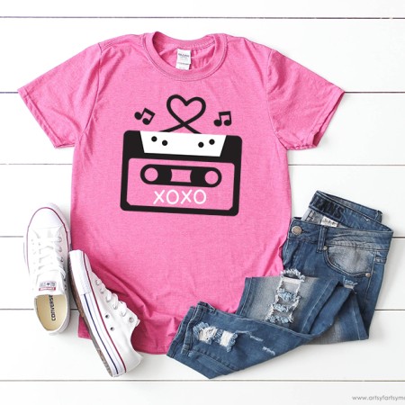 Pink t-shirt with an image of a cassette tape on it with X's and O's