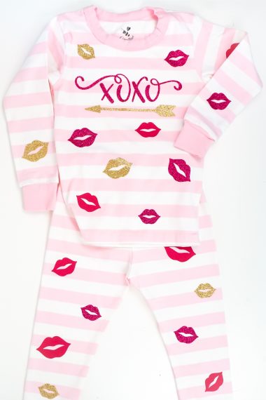 Pair of infant pink and white striped pj's with vinyl cut outs of red and gold lips, an arrow and xoxo applied to the pajama top and bottom