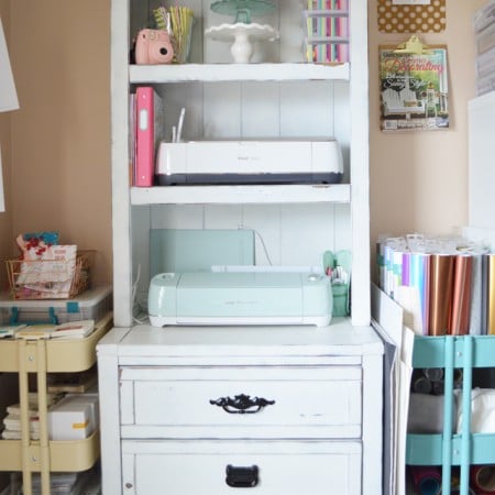 A small hutch filled with Cricut machines and supplies