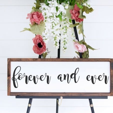 Framed white sign sitting on a tripod stand that says Forever and Ever