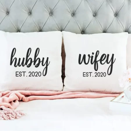 Two white pillows. One says Hubby Est 2020 and the other one says Wifey Est 2020