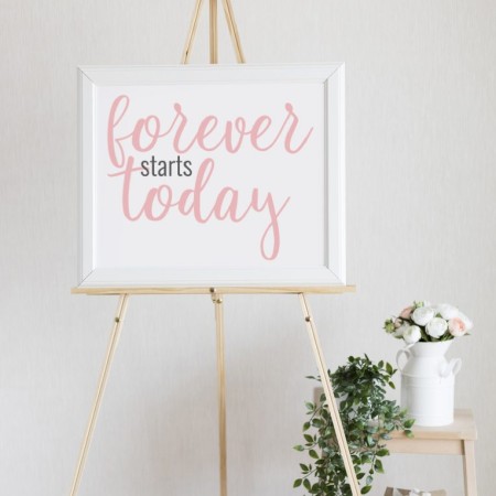 White framed sign on a tripod stand that says Forever Starts Today