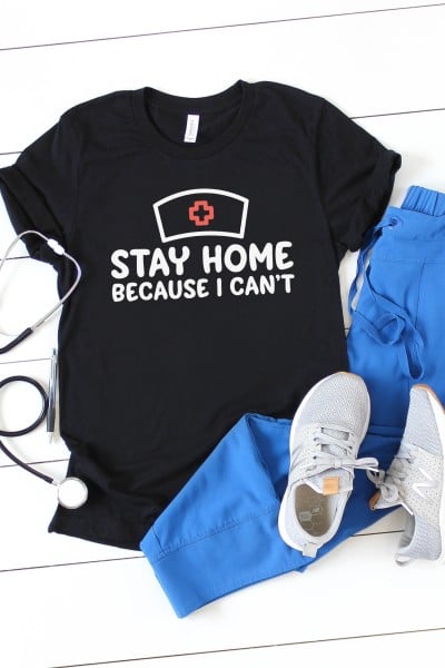 Stethoscope along with a black t-shirt with saying, "Stay home because I can't", and paired with blue scrub pants and tennis shoes.