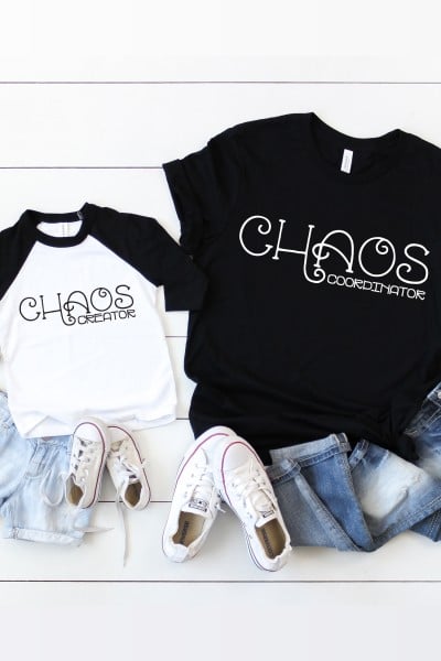 Image of an adult black t-shirt stating "Chaos Coordinator" and a child's black and white baseball style shirt that states "Chaos Creator".  The adult t-shirt is paired with blue jeans and tennis shoes and the child's t-shirt is paired with blue jean shorts and tennis shoes.