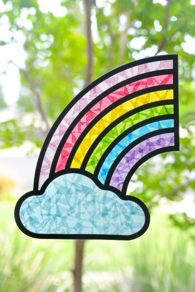 Rainbow Suncatcher hanging in a window with trees in background