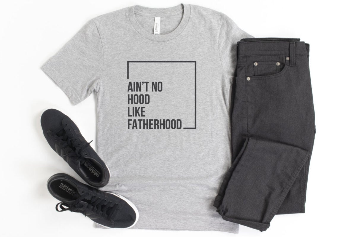 "Ain't No Hood Like Fatherhood" SVG on a gray shirt with black pants.