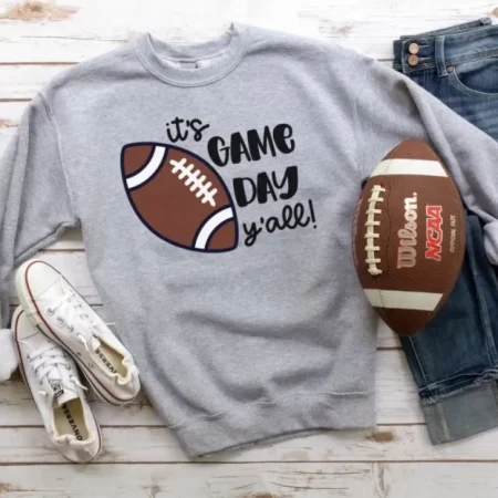Gray sweatshirt with an image of a football on it and the saying It's Game Day Y'all