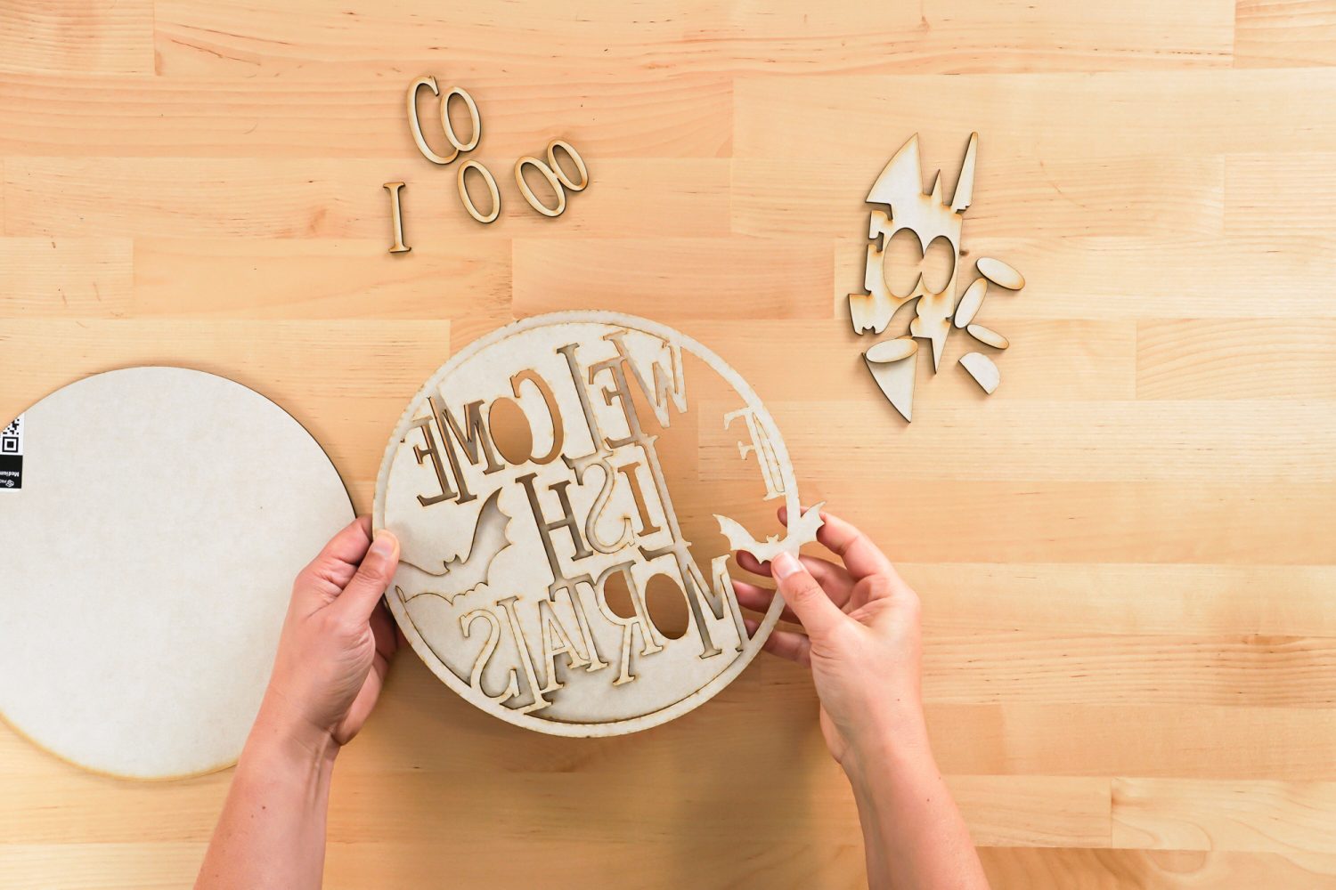 Hands removing the negative pieces from the cut out sign