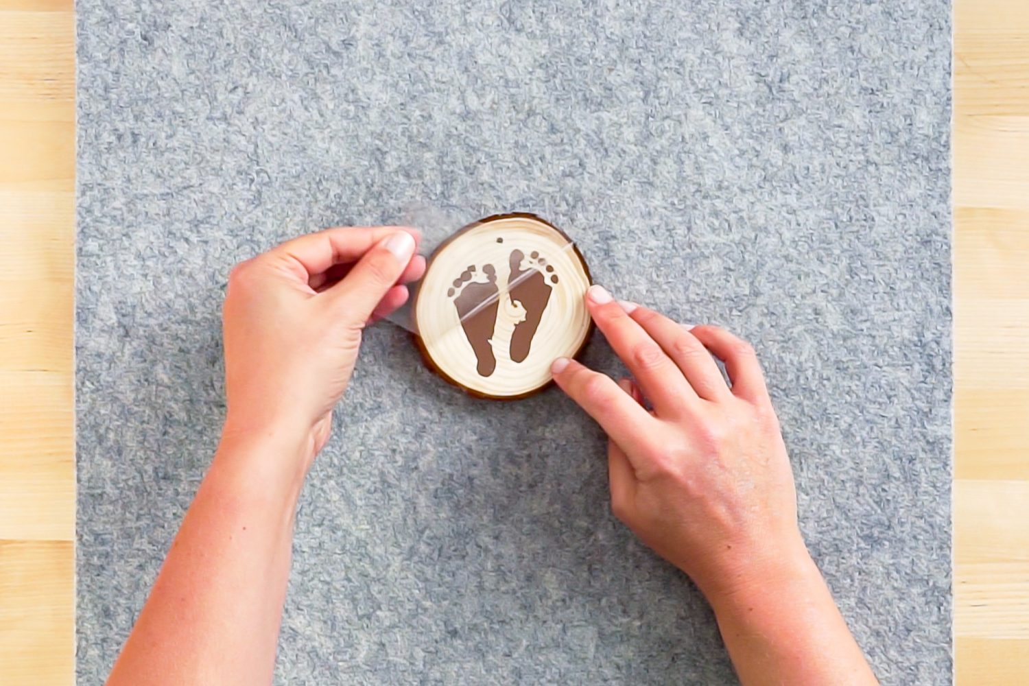 Hands peeling back the plastic carrier sheet on the ornament.