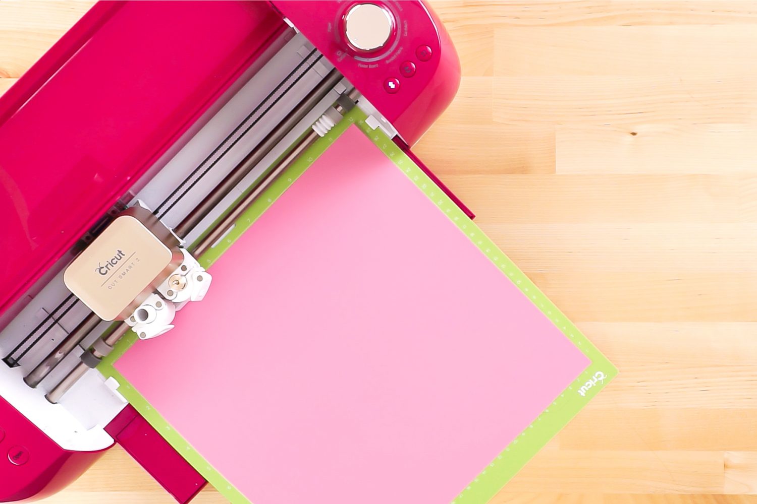 Picture of Cricut machine cutting out pink vinyl for the Happy Holly Days Christmas Banner