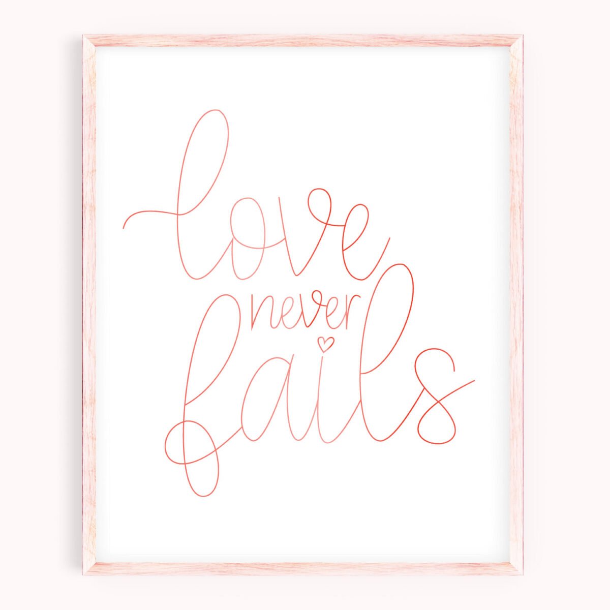 Image of picture frame with quote \"Love Never Fails\" on white background.  Quote is written in foil.