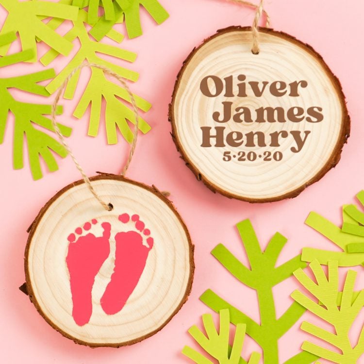 Picture of final project which displays two wood slice ornaments - one side with red newborn footprints and the other with the child's name and birthdate