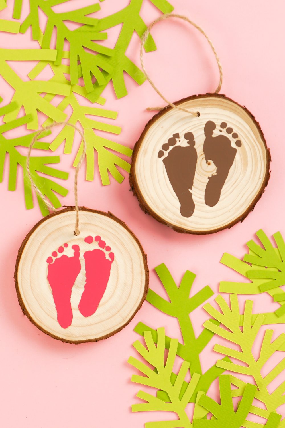 Closeup of footprint ornaments on pink background.