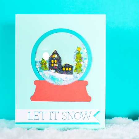 Finished snow globe shaker card on a blue background.