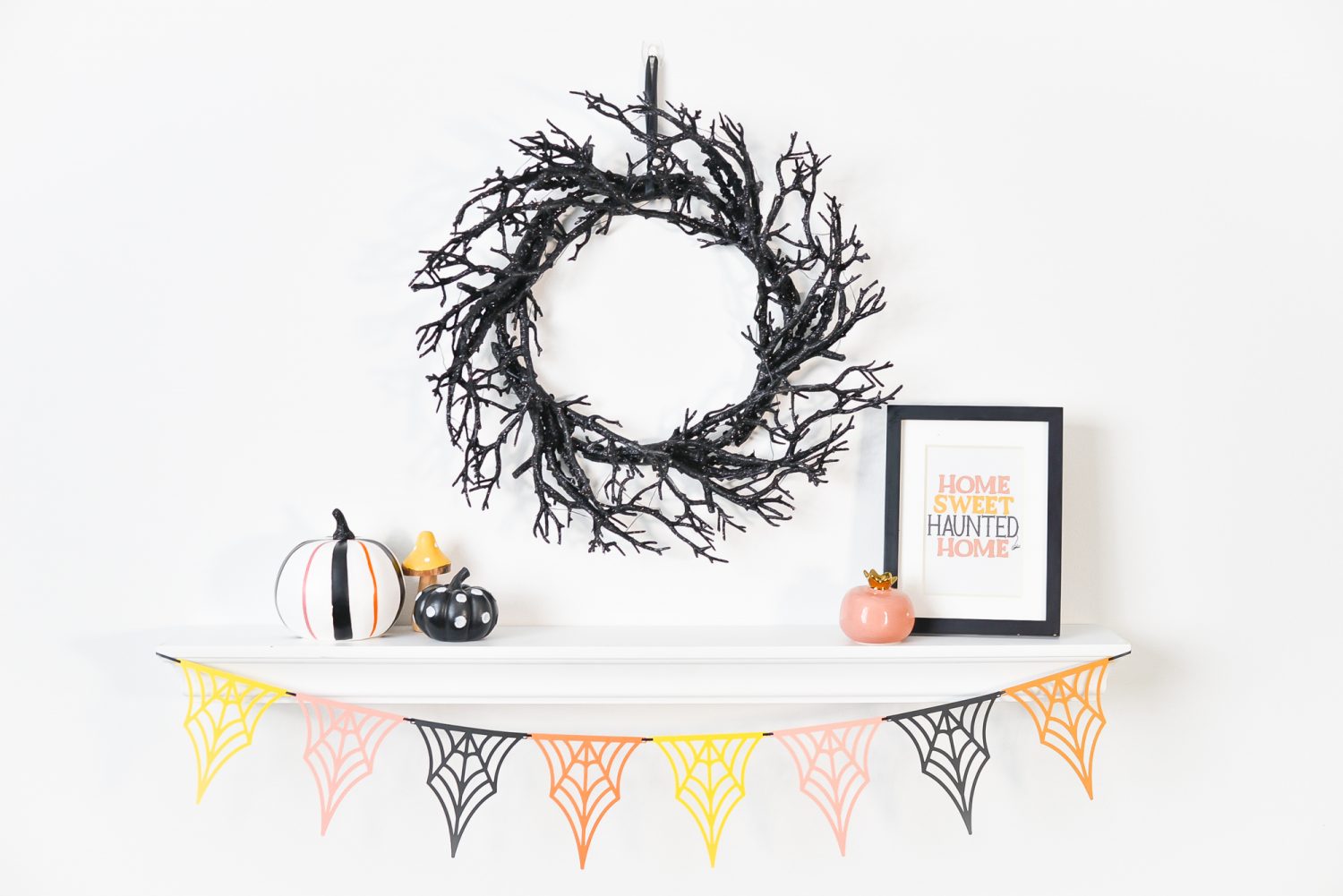 Spider web banner hanging from shelf with Halloween decorations