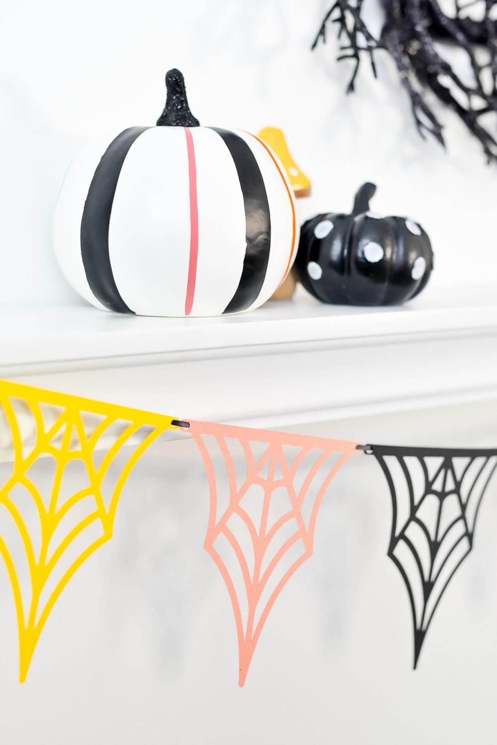 Close up of web banner hanging from shelf with Halloween pumpkins