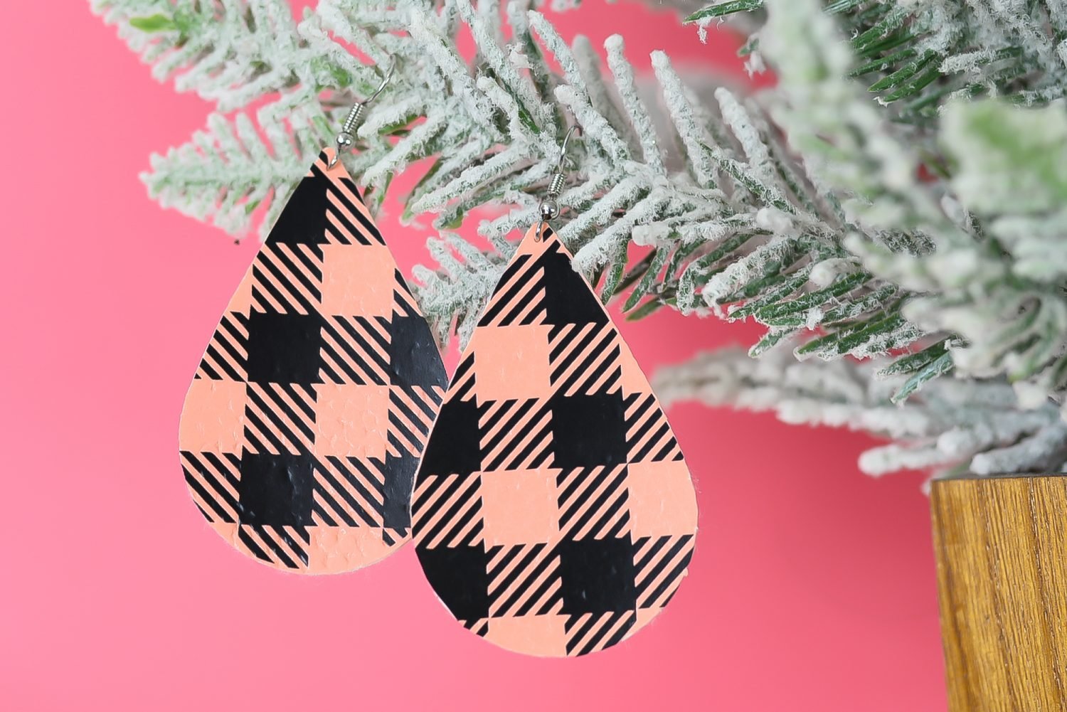 Finished pinkbuffalo plaid earrings hanging from a christmas tree branch